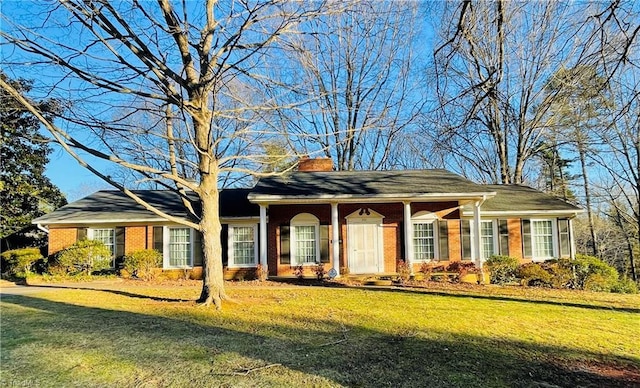 single story home with a front yard, a chimney, and brick siding