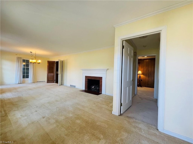 unfurnished living room with visible vents, ornamental molding, carpet floors, a brick fireplace, and a chandelier