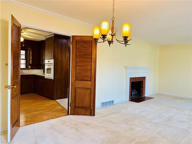 unfurnished living room with light carpet, baseboards, visible vents, crown molding, and a fireplace