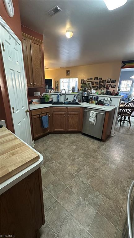 kitchen featuring kitchen peninsula, dishwasher, and sink