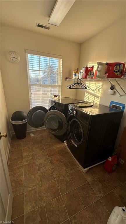 laundry area with washing machine and dryer and dark tile patterned floors