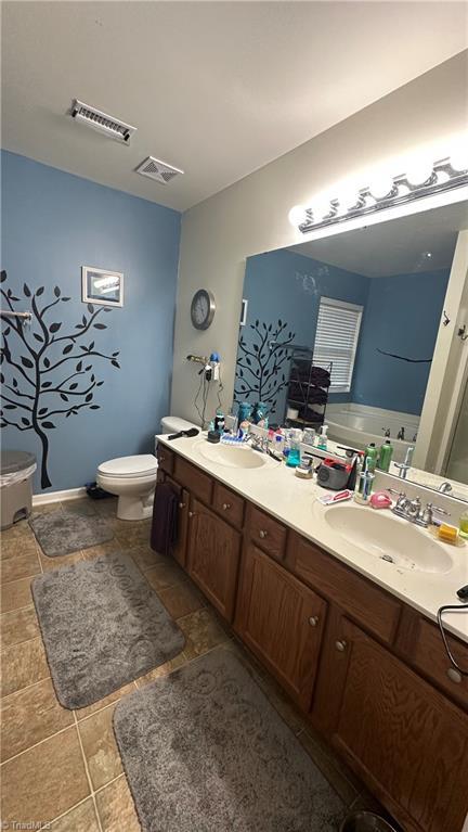 bathroom featuring vanity, toilet, and a washtub