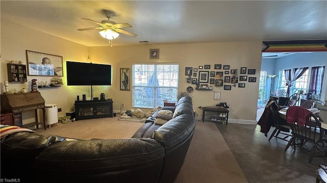 living room featuring a wealth of natural light, ceiling fan, and concrete floors