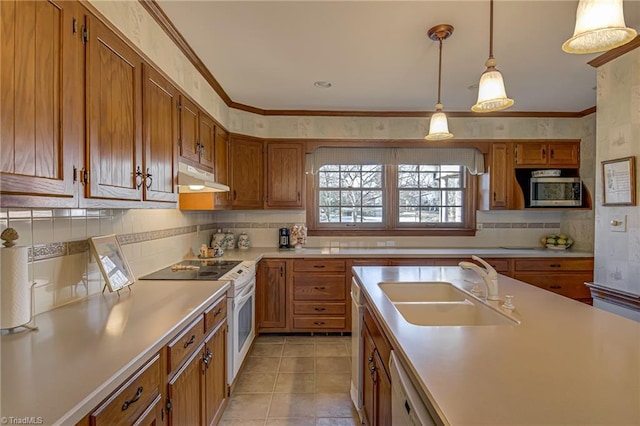 kitchen featuring brown cabinets, white appliances, light countertops, and under cabinet range hood