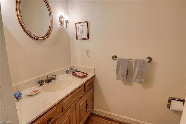 bathroom featuring vanity, baseboards, and wood finished floors