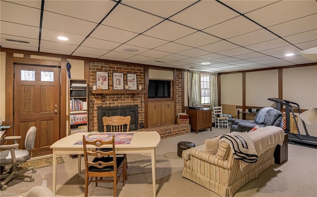 living area with light carpet, a fireplace, and a paneled ceiling