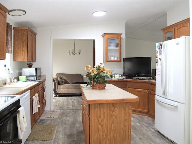 kitchen with an inviting chandelier, decorative light fixtures, a center island, white appliances, and light hardwood / wood-style floors