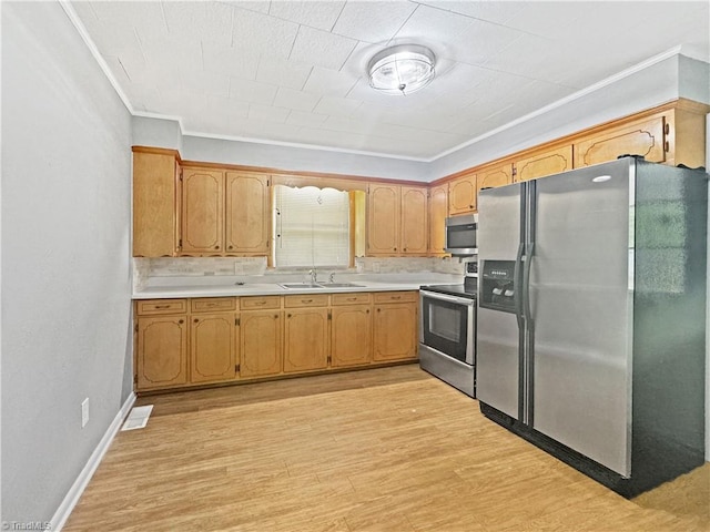 964 Mountain View Rd, North Wilkesboro, NC 28659 - kitchen featuring stainless steel appliances, ornamental molding, a sink, light countertops, and light wood-style flooring