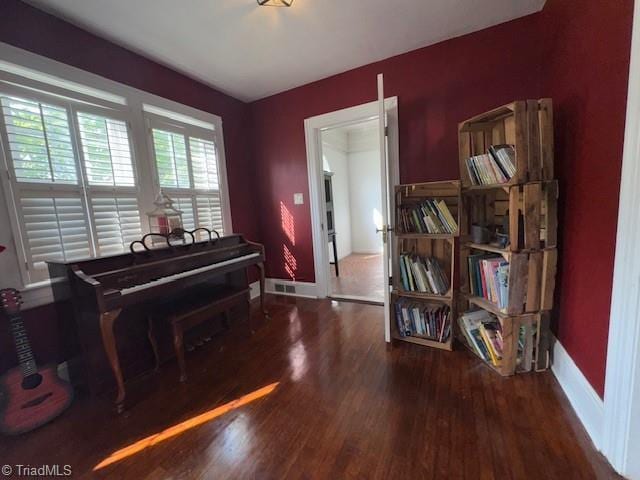 sitting room with baseboards and wood finished floors