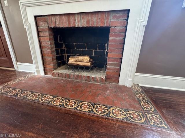 details featuring a brick fireplace and baseboards