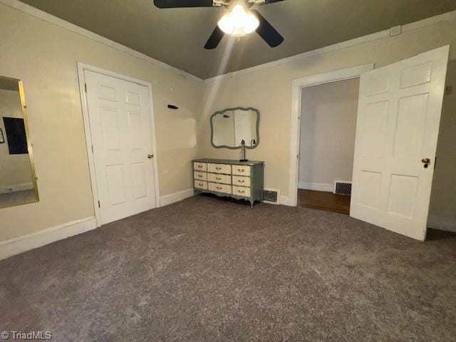 unfurnished bedroom featuring visible vents, ornamental molding, and carpet flooring