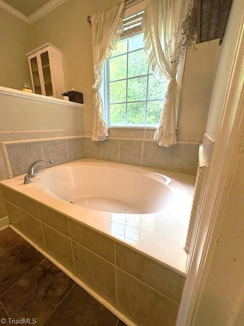 full bath with tile patterned floors, ornamental molding, and a bath