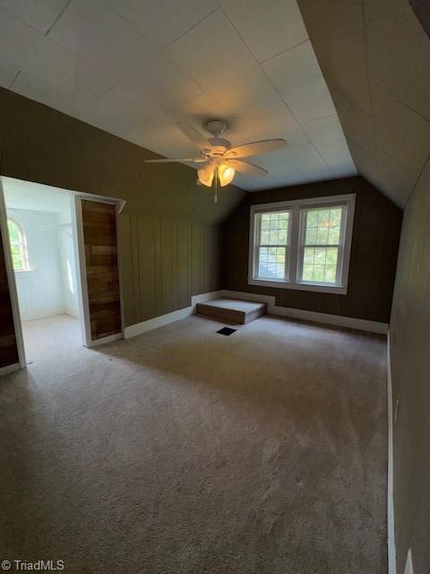 additional living space with carpet floors, a ceiling fan, and lofted ceiling