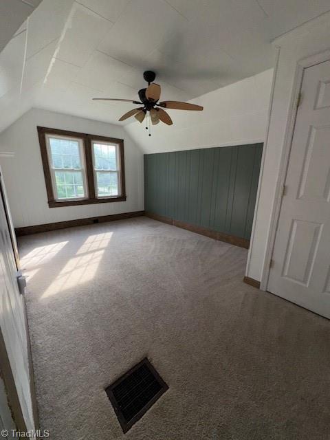 additional living space featuring carpet floors, ceiling fan, vaulted ceiling, and visible vents