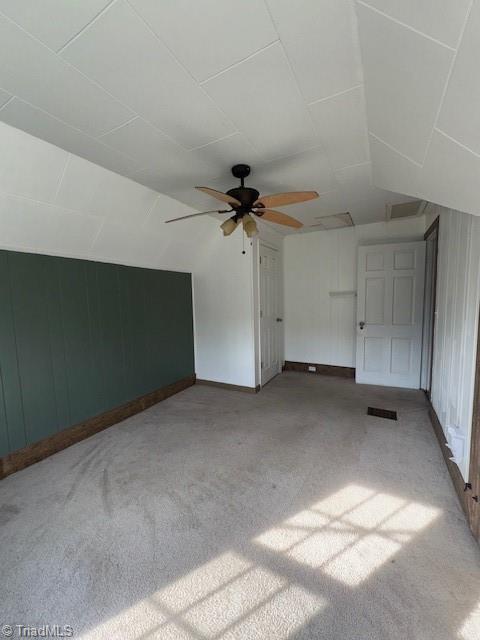 additional living space with a ceiling fan, vaulted ceiling, and carpet flooring