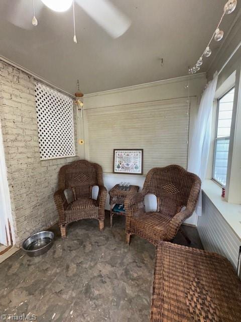 sitting room featuring crown molding and brick wall