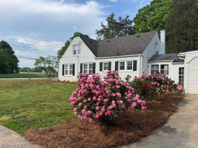view of front of house with a front lawn and a chimney