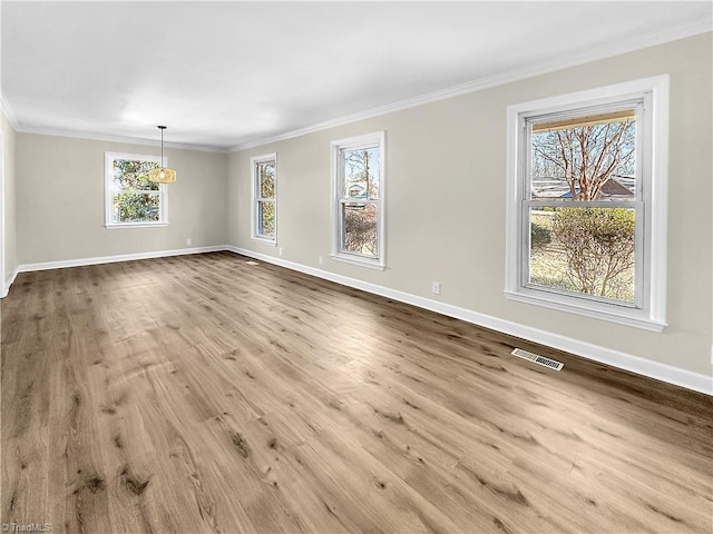 empty room with ornamental molding and light wood-type flooring