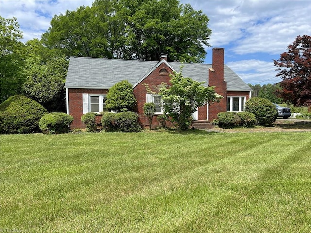 1716 US Highway 220, Stokesdale, NC 27357 - view of front facade featuring brick siding, a front yard, a shingled roof, and a chimney