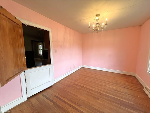 1716 US Highway 220, Stokesdale, NC 27357 - spare room featuring a chandelier, wood finished floors, and baseboards