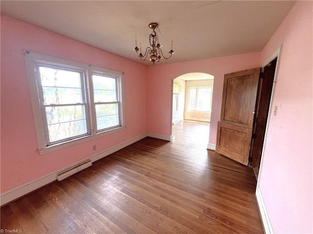 1716 US Highway 220, Stokesdale, NC 27357 - unfurnished dining area with arched walkways, baseboard heating, baseboards, and wood finished floors