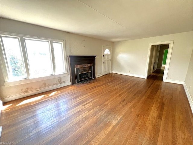 1716 US Highway 220, Stokesdale, NC 27357 - unfurnished living room featuring wood finished floors, baseboards, and a fireplace with flush hearth