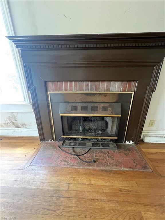 1716 US Highway 220, Stokesdale, NC 27357 - detailed view of a fireplace with flush hearth, baseboards, and wood finished floors
