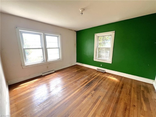 1716 US Highway 220, Stokesdale, NC 27357 - unfurnished room featuring a baseboard heating unit, wood finished floors, and baseboards