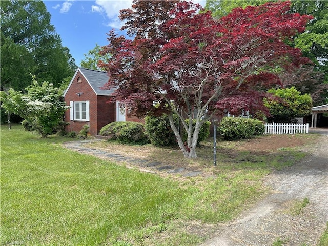 1716 US Highway 220, Stokesdale, NC 27357 - view of front facade featuring brick siding, a carport, dirt driveway, and roof with shingles