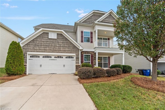 craftsman-style home with a balcony, a garage, and a front lawn