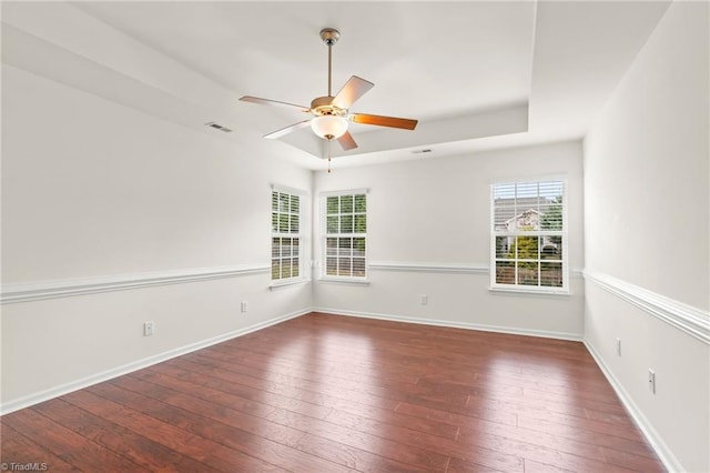 4887 Old Towne Village Cir, Pfafftown, NC 27040 - spare room featuring visible vents, hardwood / wood-style floors, baseboards, a tray ceiling, and a ceiling fan