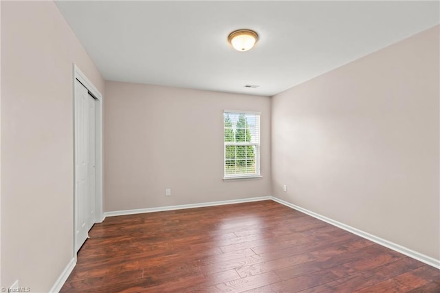 unfurnished bedroom with a closet and dark hardwood / wood-style floors