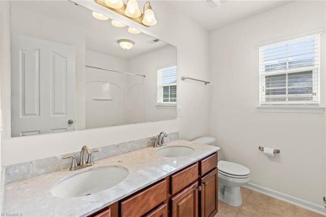 bathroom with vanity, toilet, tile patterned floors, and plenty of natural light