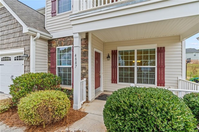 4887 Old Towne Village Cir, Pfafftown, NC 27040 - doorway to property with a shingled roof, covered porch, and stone siding