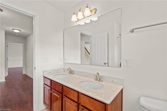 bathroom with vanity, toilet, and hardwood / wood-style flooring