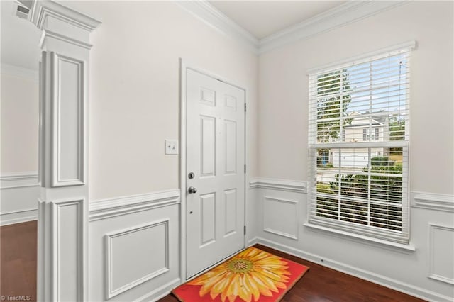 doorway with ornamental molding, dark wood-type flooring, and ornate columns