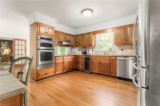 5001 Edinborough Rd, Greensboro, NC 27406 - kitchen with under cabinet range hood, stainless steel appliances, light wood-type flooring, tasteful backsplash, and beverage cooler