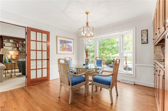 5001 Edinborough Rd, Greensboro, NC 27406 - dining area with an inviting chandelier, ornamental molding, visible vents, and light wood-style flooring