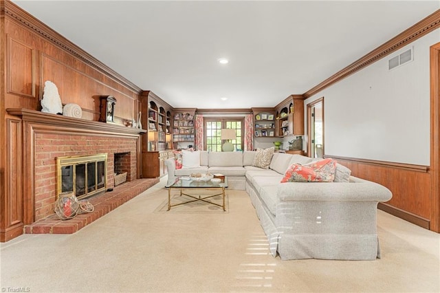 5001 Edinborough Rd, Greensboro, NC 27406 - living room with wood walls, light colored carpet, visible vents, ornamental molding, and a fireplace