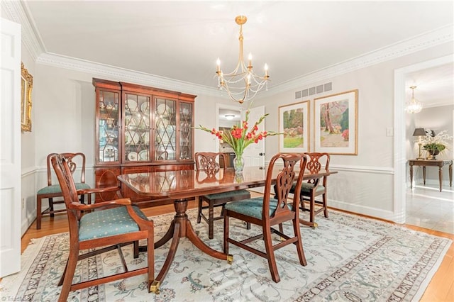 5001 Edinborough Rd, Greensboro, NC 27406 - dining room with an inviting chandelier, wood finished floors, visible vents, and ornamental molding
