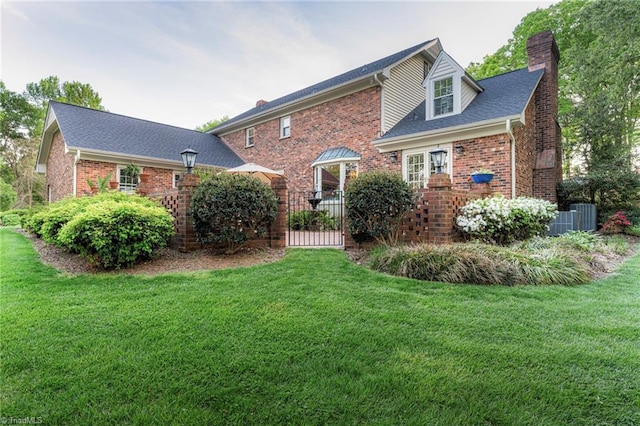 5001 Edinborough Rd, Greensboro, NC 27406 - rear view of property with a chimney, brick siding, central air condition unit, and a lawn