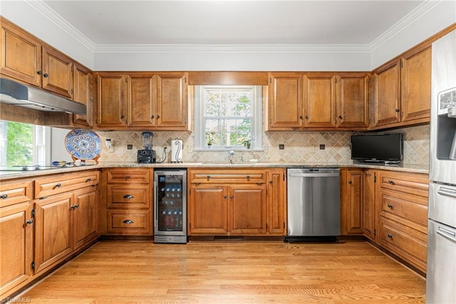 5001 Edinborough Rd, Greensboro, NC 27406 - kitchen featuring a healthy amount of sunlight, brown cabinetry, under cabinet range hood, appliances with stainless steel finishes, and wine cooler