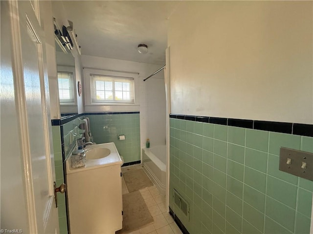 bathroom with vanity, shower / washtub combination, tile patterned floors, and tile walls