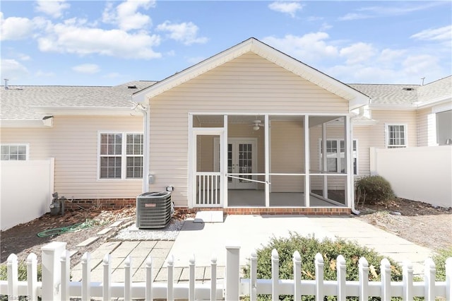 rear view of property with a fenced front yard, a patio, central AC, and a sunroom