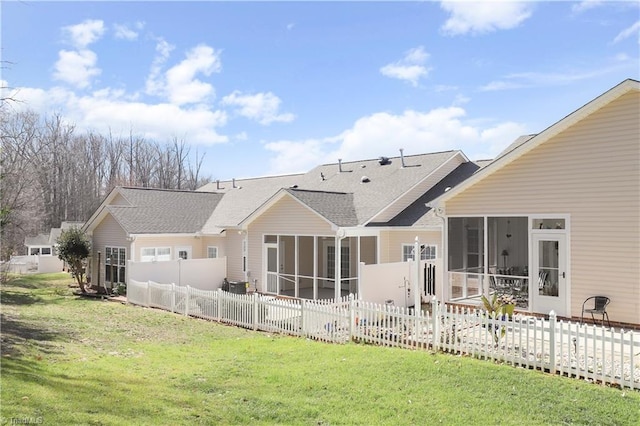 back of property featuring a yard, fence, and a sunroom