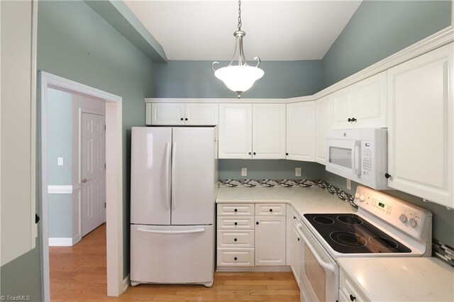 kitchen with light wood-type flooring, decorative light fixtures, white appliances, white cabinets, and light countertops