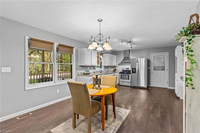 dining area with an inviting chandelier, sink, and dark hardwood / wood-style flooring