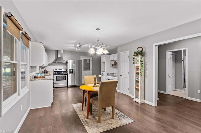 dining space featuring sink, a notable chandelier, and dark hardwood / wood-style flooring