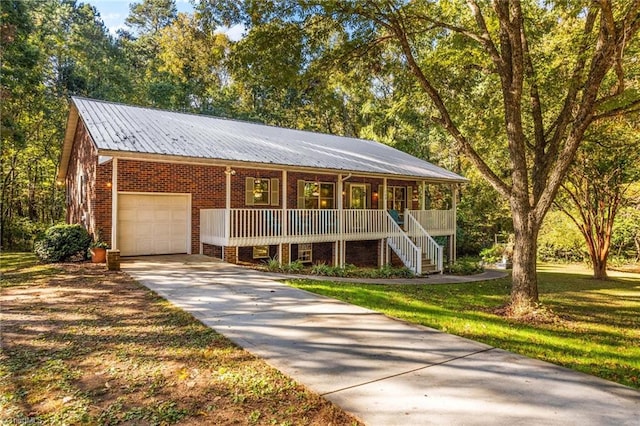 view of front of home featuring covered porch, a front yard, and a garage