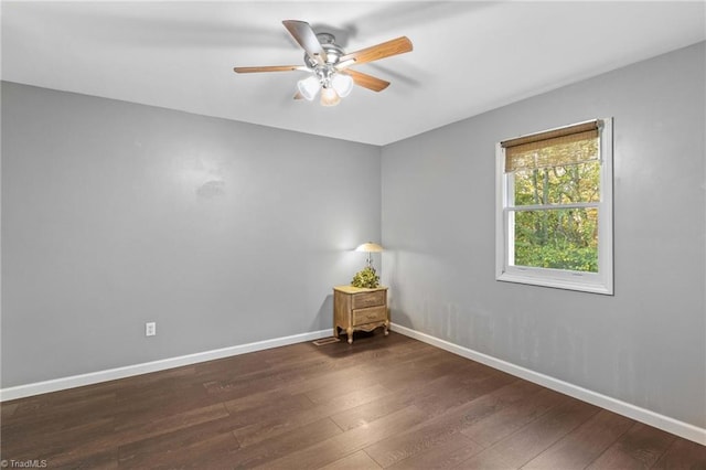 spare room featuring dark wood-type flooring and ceiling fan